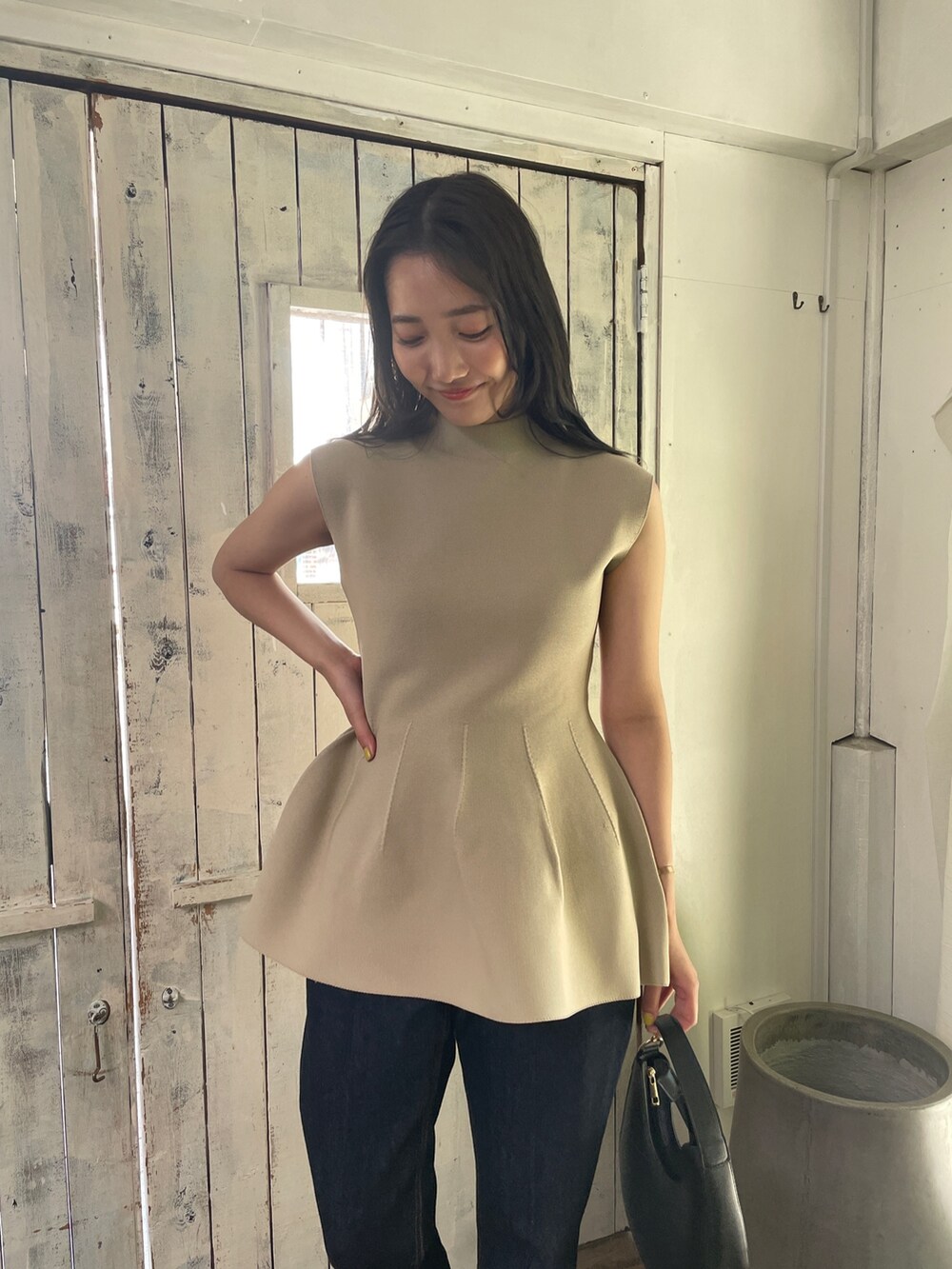 ベージュ系のニット/セーター、ブルー系のデニムパンツ、ベージュ系のサンダルを着用したレディースの春コーディネートの4枚目の写真