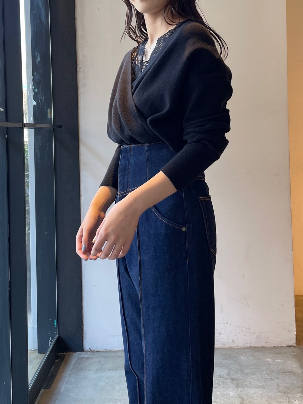 ブラック系のブーツ、ブルー系のデニムパンツ、ブラック系のニット/セーターを着用したレディースの冬コーディネートの5枚目の写真