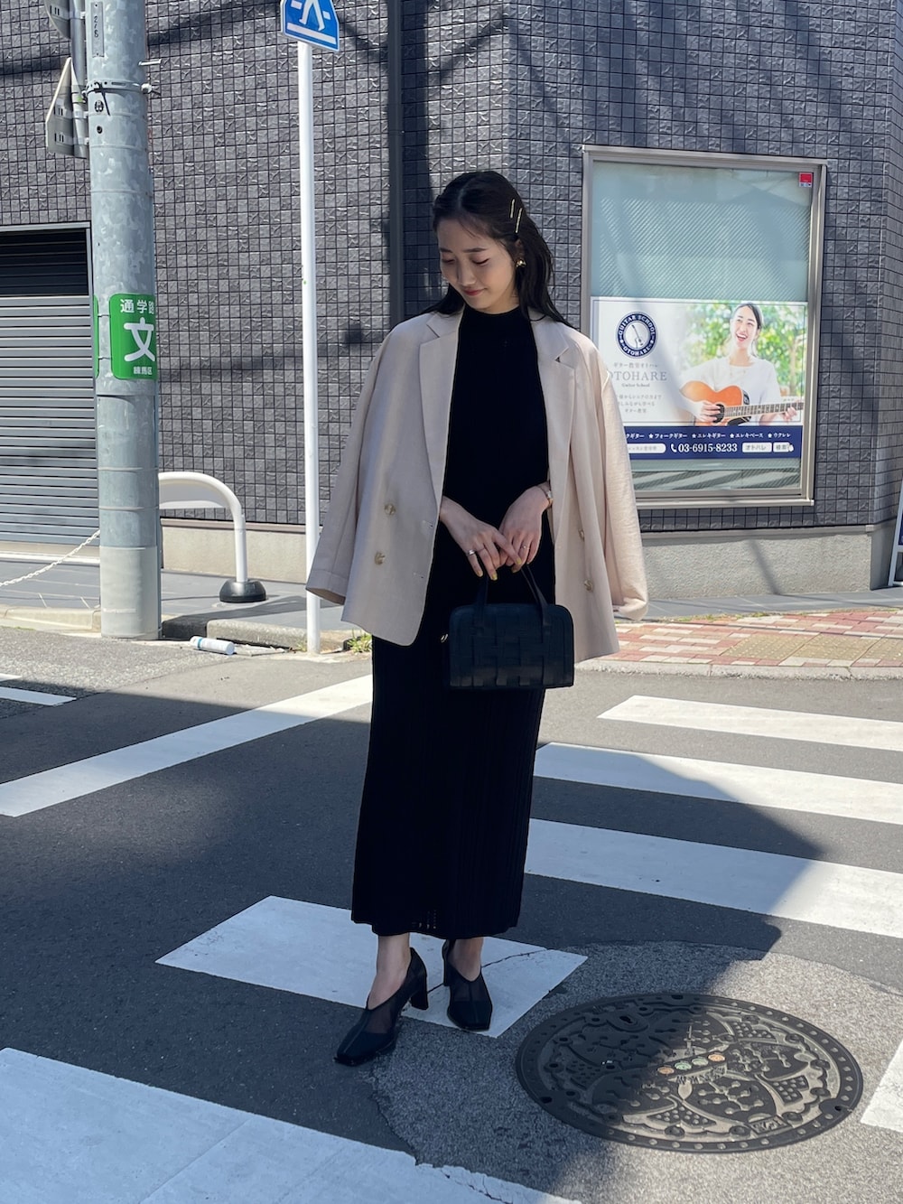 ブラック系のショルダーバッグ、ブラック系のワンピース、ベージュ系のテーラードジャケットを着用したレディースの春コーディネートの2枚目の写真