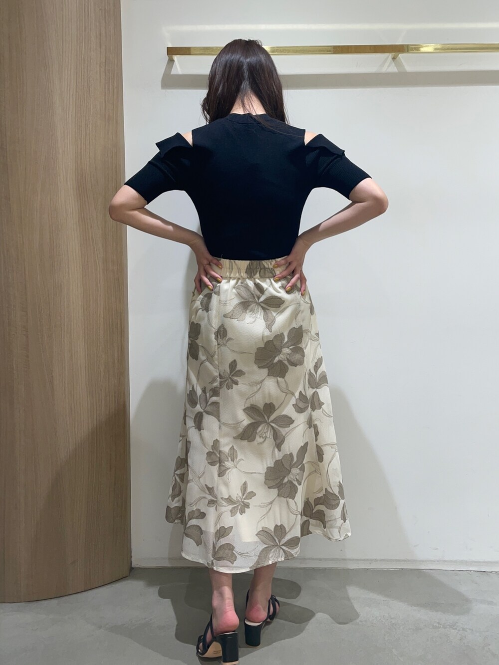 ブラック系のニット/セーター、ブラック系のサンダル、ベージュ系のスカートを着用したレディースの春コーディネートの8枚目の写真