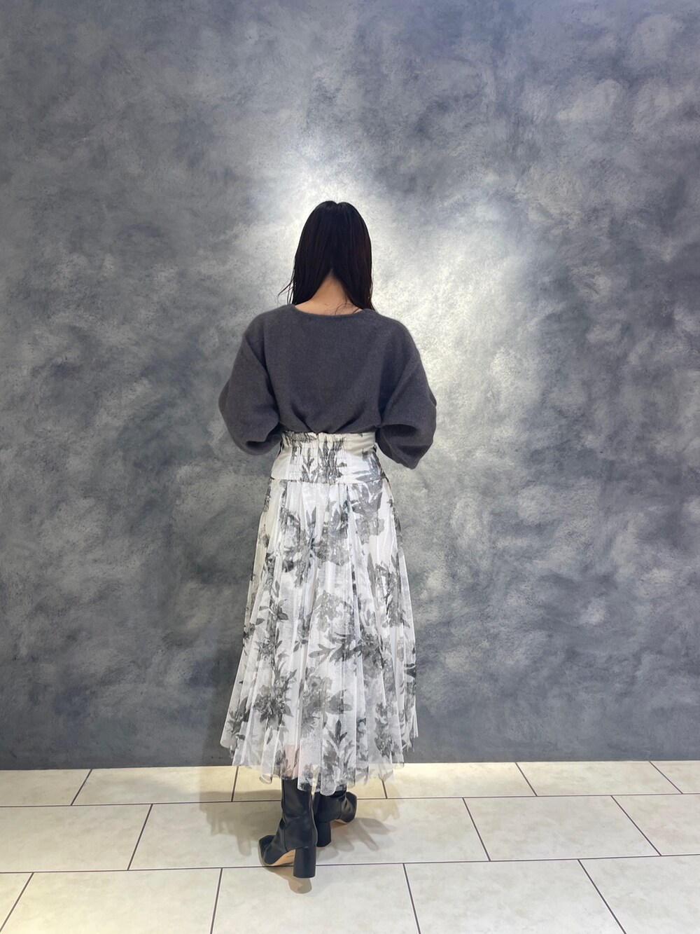 ブラック系のスカート、ブラック系のブーツ、グレー系のニット/セーターを着用したレディースの秋コーディネートの6枚目の写真