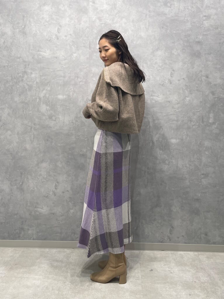 ベージュ系のブーツ、ベージュ系のカーディガン/ボレロ、パープル系のスカートを着用したレディースの秋コーディネートの5枚目の写真