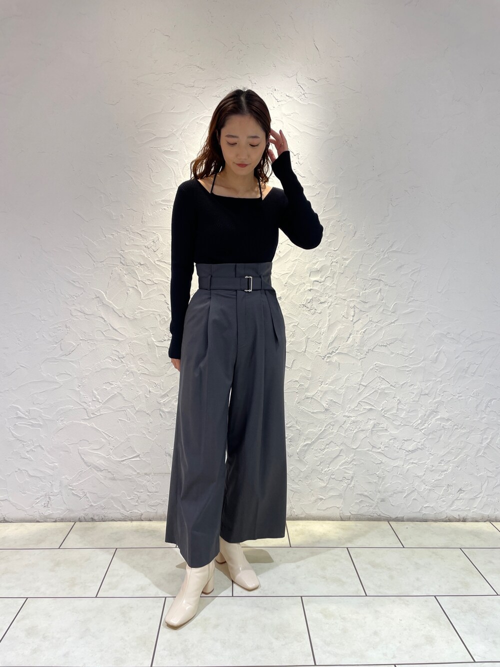 グレー系のその他パンツ、ブラック系のニット/セーター、ホワイト系のブーツを着用したレディースの冬コーディネートの3枚目の写真