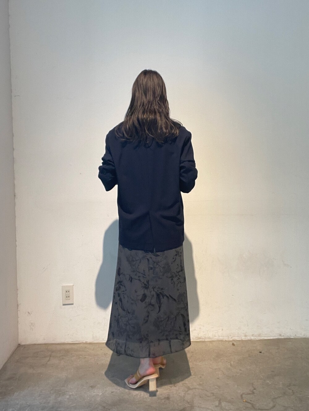 グレー系のスカート、イエロー系のサンダル、ブルー系のテーラードジャケットを着用したレディースの夏コーディネートの4枚目の写真