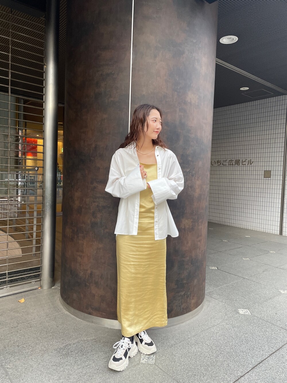 ブラック系のスニーカー、ホワイト系のシャツ/ブラウス、イエロー系のワンピースを着用したレディースの冬コーディネートの3枚目の写真