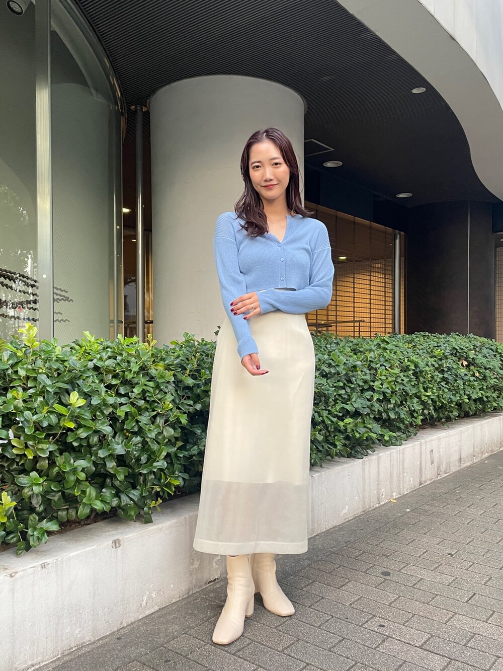 ホワイト系のブーツ、ホワイト系のスカート、ブルー系のカーディガン/ボレロを着用したレディースの秋コーディネートの2枚目の写真
