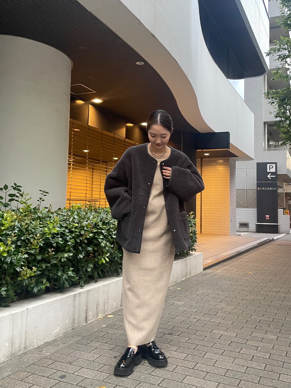 ベージュ系のワンピース、ブラック系のローファー、グレー系のブルゾンを着用したレディースの夏コーディネートの3枚目の写真