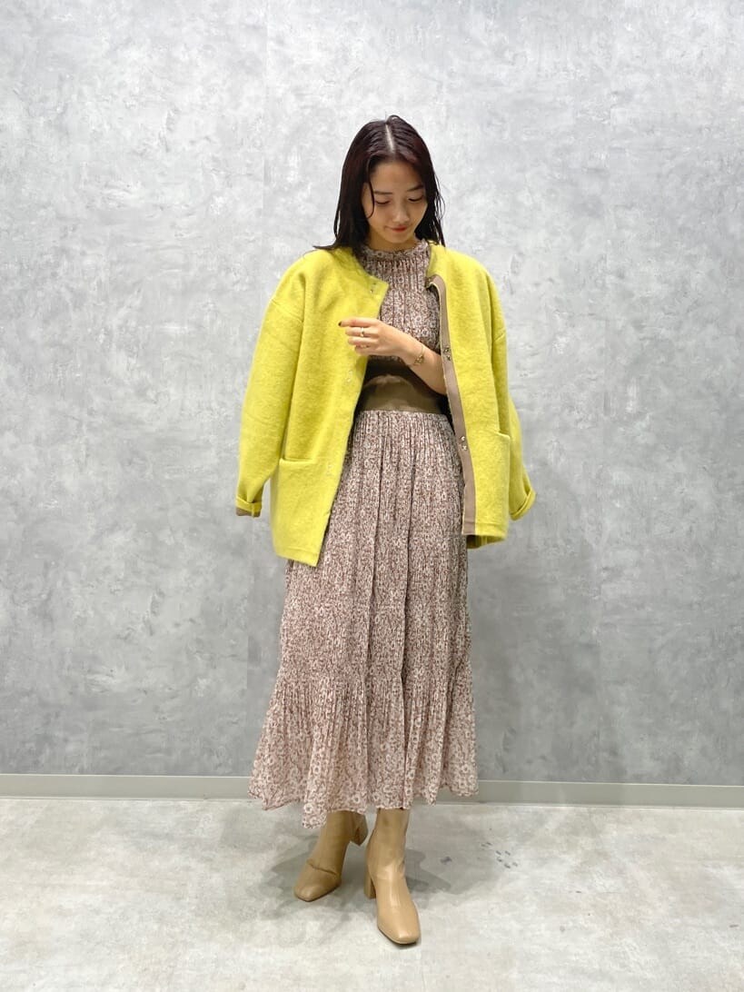 ベージュ系のワンピース、ベージュ系のブーツ、イエロー系のカーディガン/ボレロを着用したレディースの秋コーディネートの2枚目の写真