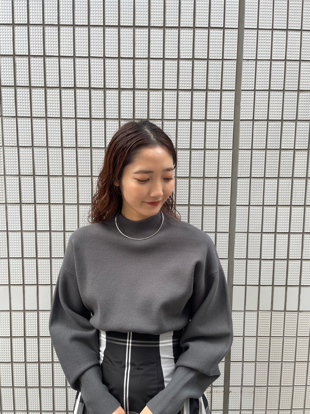 ブラック系のワンピース、ブラック系のブーツ、ブラック系のハンドバッグを着用したレディースの冬コーディネートの8枚目の写真