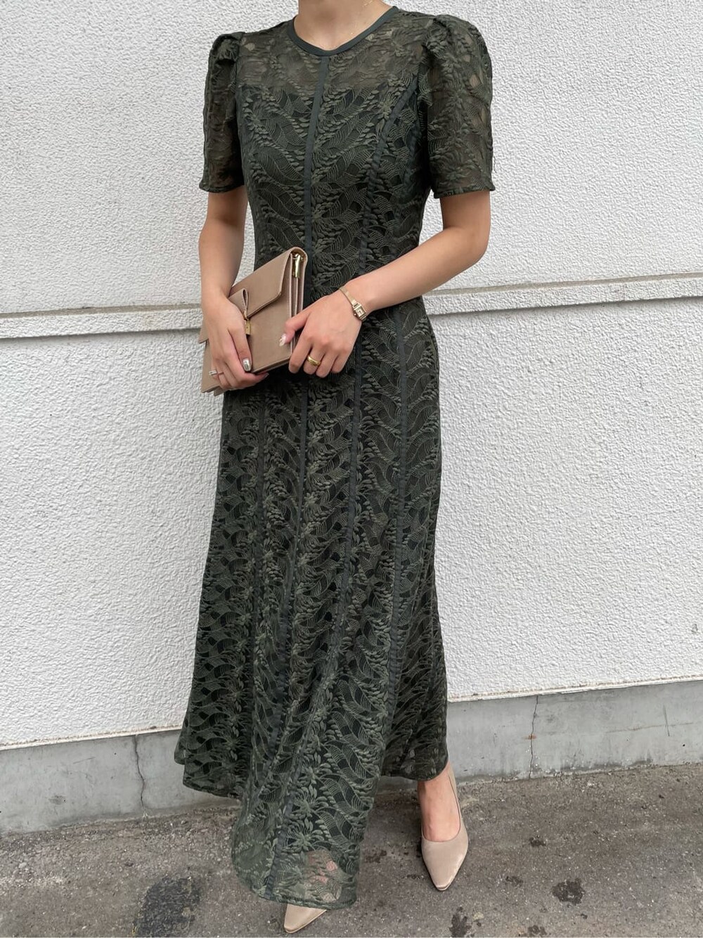 グリーン系のドレス、ベージュ系のパンプス、ブラウン系のクラッチバッグを着用したレディースの夏コーディネートの4枚目の写真