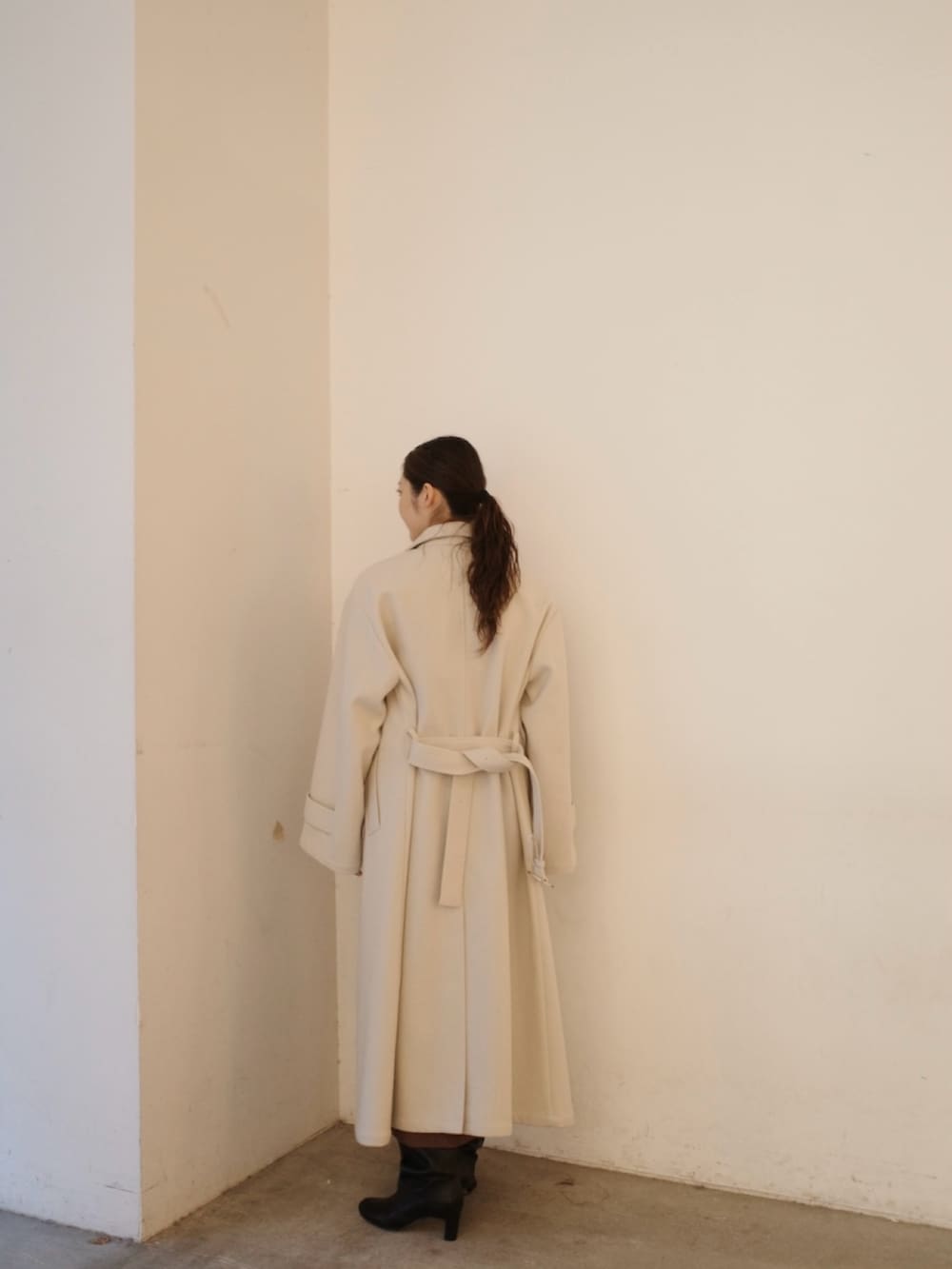 グレー系のステンカラーコート、ブラウン系のワンピースを着用したレディースの秋コーディネートの4枚目の写真