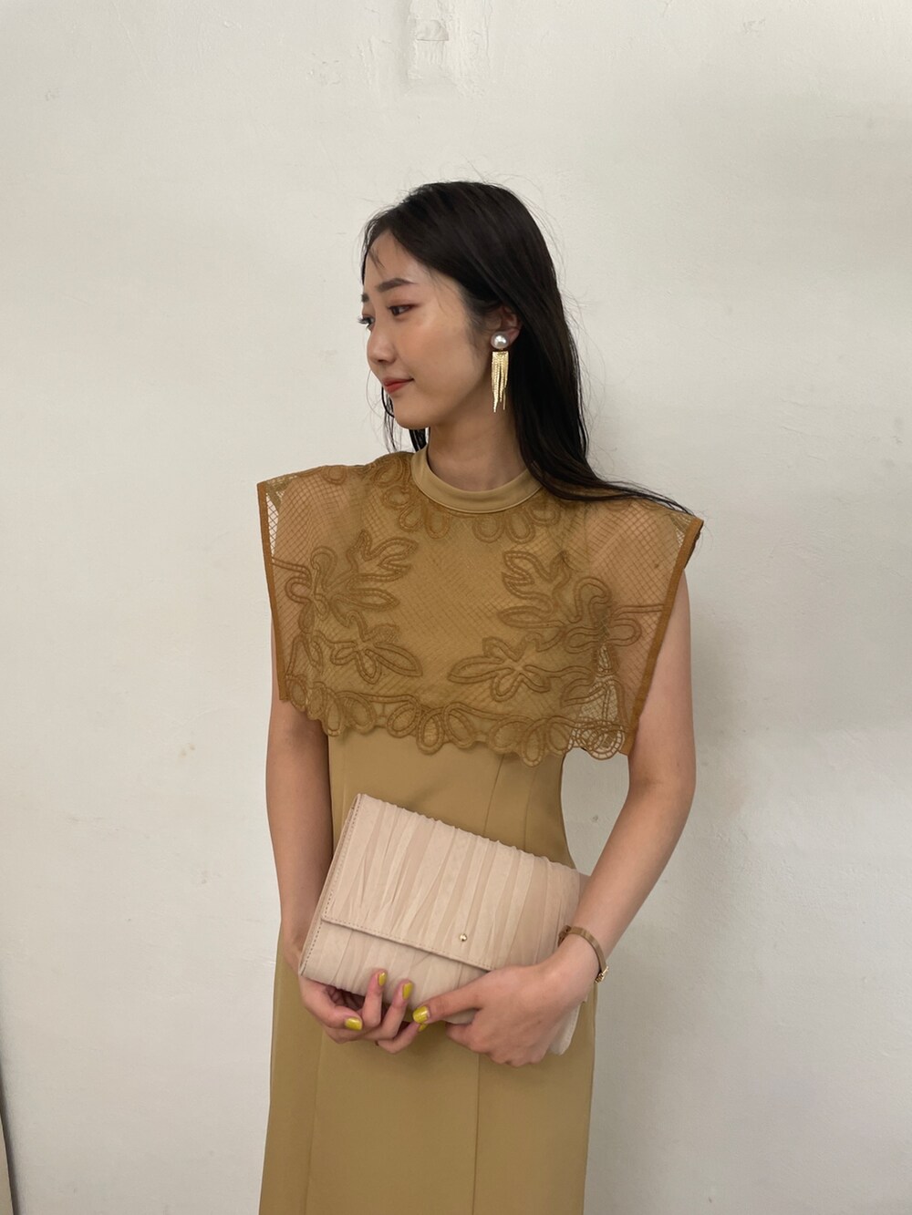 ベージュ系のドレス、ベージュ系のハンドバッグ、ベージュ系のパンプスを着用したレディースの春コーディネートの5枚目の写真