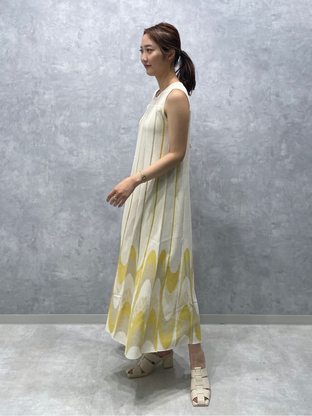 ホワイト系のサンダル、イエロー系のワンピースを着用したレディースの夏コーディネートの4枚目の写真