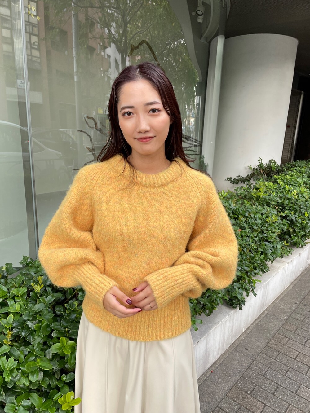 ホワイト系のブーツ、ホワイト系のスカート、イエロー系のニット/セーターを着用したレディースの秋コーディネートの5枚目の写真