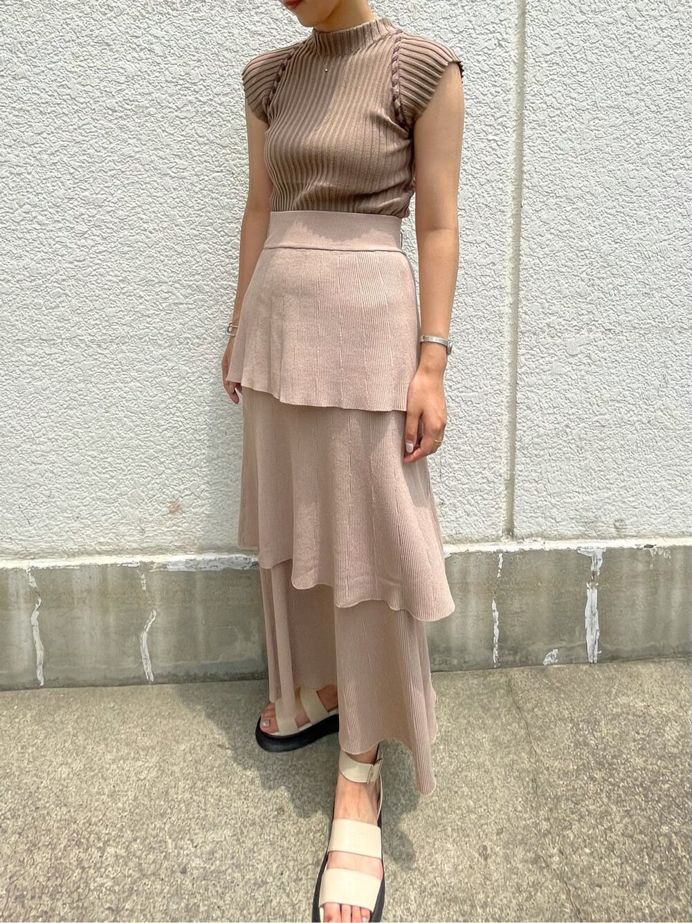 ベージュ系のスカート、ホワイト系のサンダル、ベージュ系のニット/セーターを着用したレディースの夏コーディネートの2枚目の写真
