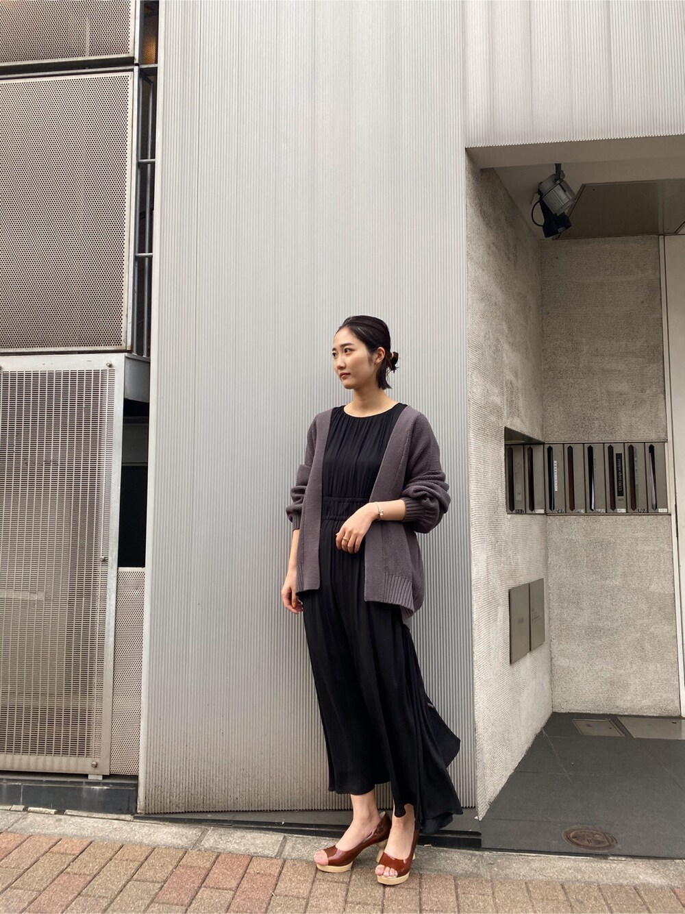 ブラウン系のパンプス、グレー系のカーディガン/ボレロ、ブラック系のワンピースを着用したレディースの春コーディネートの8枚目の写真