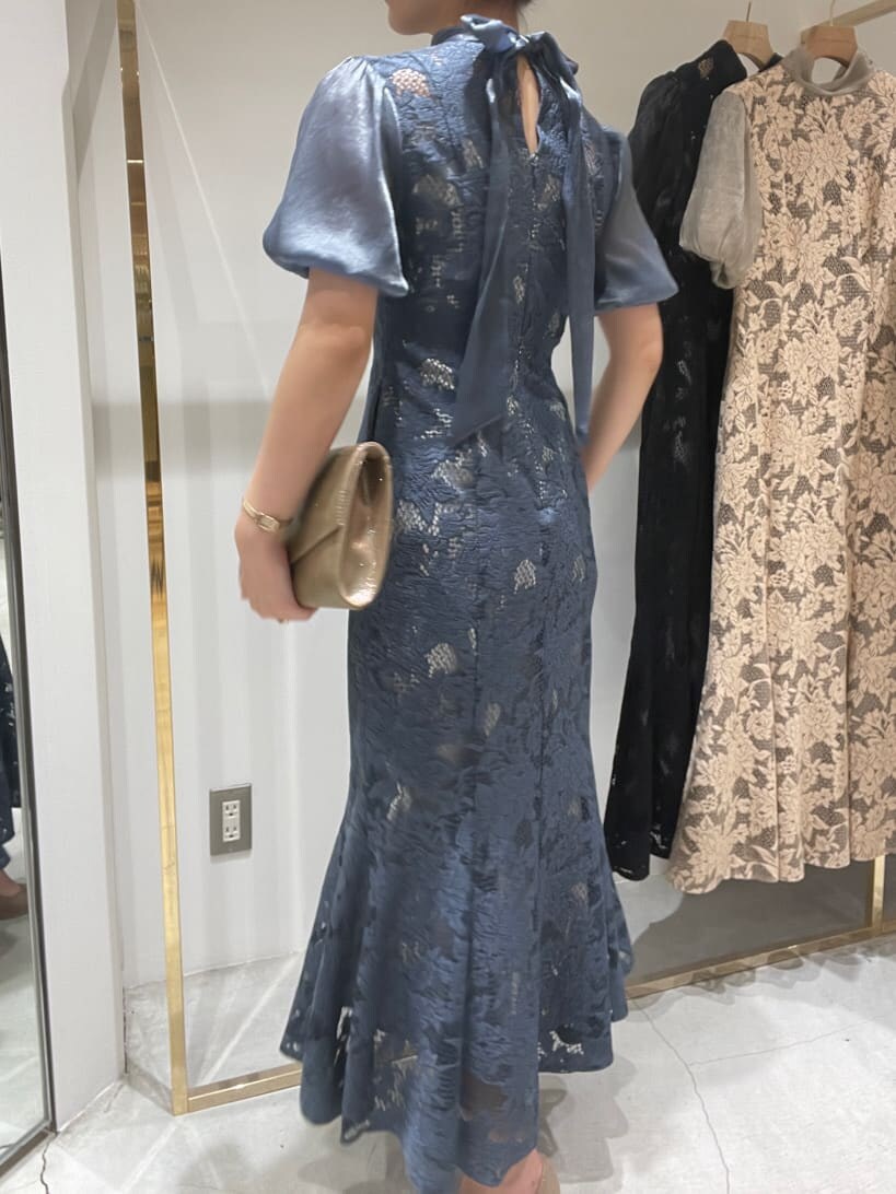 ゴールド系のクラッチバッグ、ブルー系のドレスを着用したレディースの春コーディネートの5枚目の写真