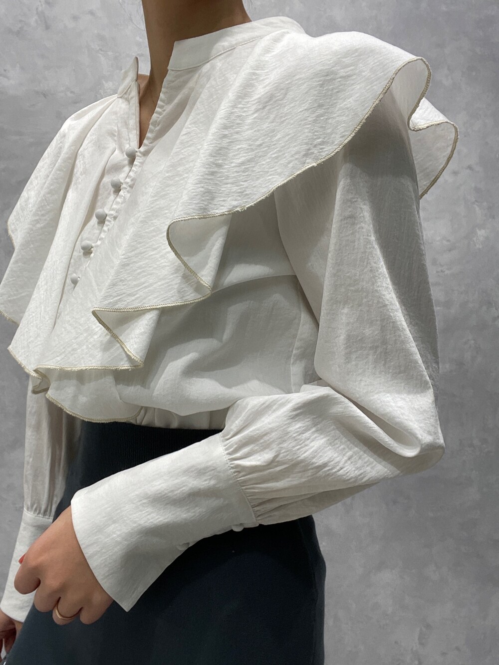 ホワイト系のカーディガン/ボレロ、ブラック系のブーツ、グリーン系のスカートを着用したレディースの冬コーディネートの9枚目の写真