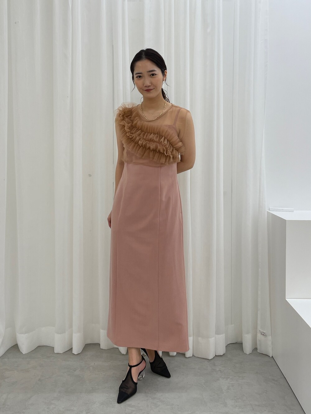 ブラック系のパンプス、ピンク系のドレスを着用したレディースの春コーディネートの5枚目の写真