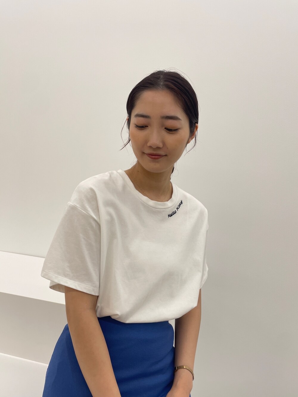 ブルー系のスカート、ホワイト系のTシャツ/カットソー、ブラック系のサンダルを着用したレディースの春コーディネートの4枚目の写真
