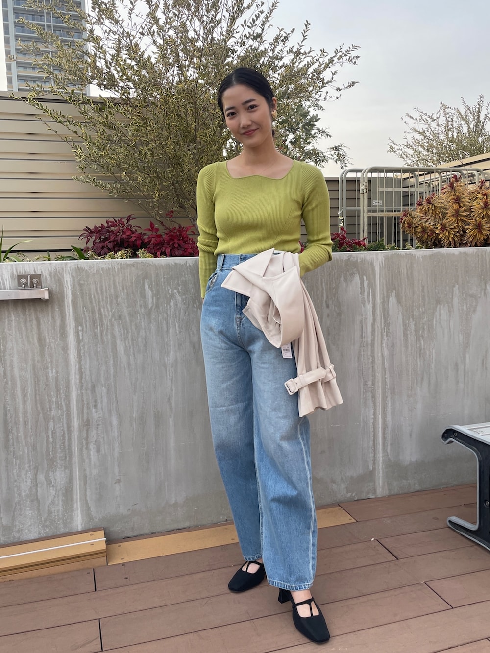 ブルー系のデニムパンツ、ホワイト系のトレンチコート、グリーン系のニット/セーターを着用したレディースの冬コーディネートの6枚目の写真