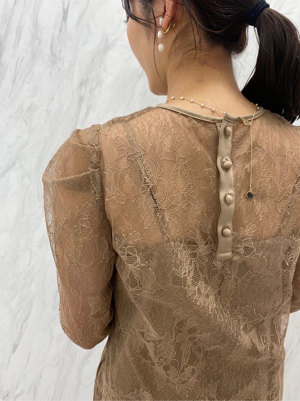 ゴールド系のパンプス、ゴールド系のクラッチバッグ、ベージュ系のドレスを着用したレディースの夏コーディネートの6枚目の写真