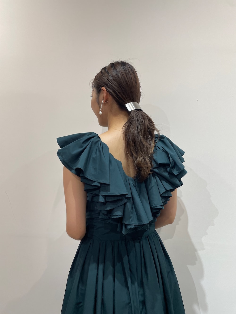 ベージュ系のパンプス、グリーン系のドレス、シルバー系のバレッタ/ヘアクリップを着用したレディースの夏コーディネートの6枚目の写真