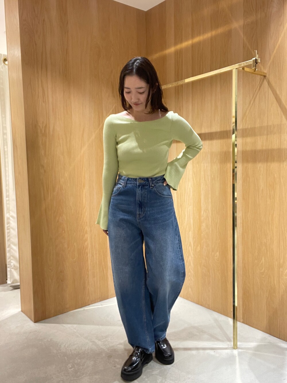 ブルー系のデニムパンツ、ホワイト系のブルゾン、グリーン系のニット/セーターを着用したレディースの秋コーディネートの6枚目の写真