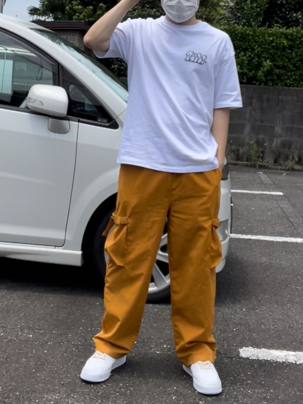 ホワイト系のTシャツ/カットソー、イエロー系のカーゴパンツ、イエロー系のスニーカーを着用したメンズの夏コーディネートの3枚目の写真
