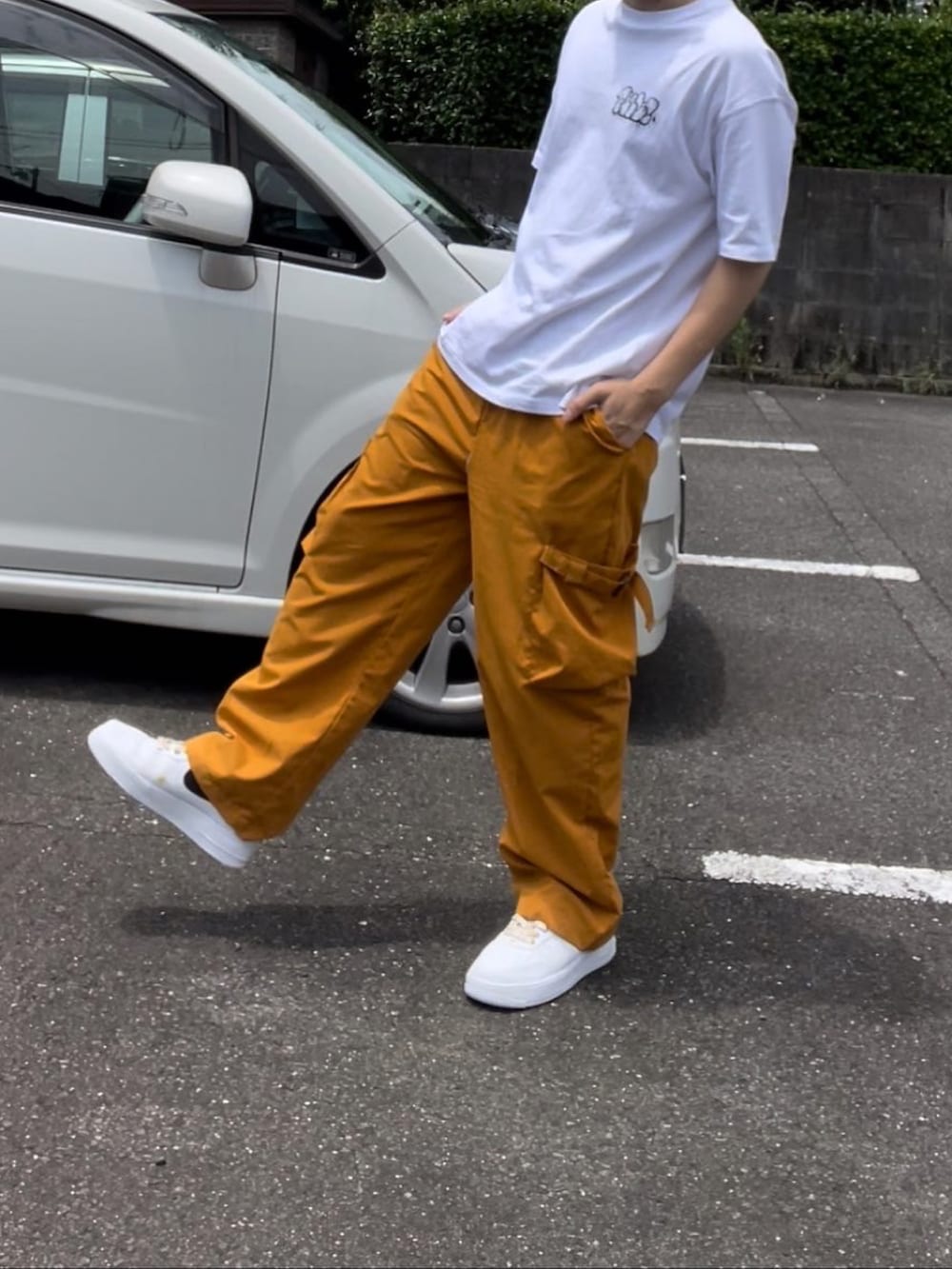 ホワイト系のTシャツ/カットソー、イエロー系のカーゴパンツ、イエロー系のスニーカーを着用したメンズの夏コーディネートの2枚目の写真