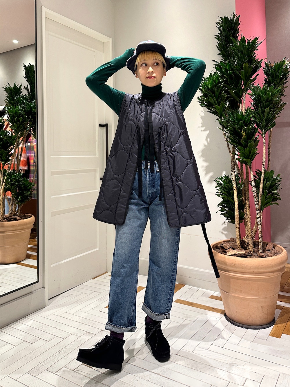 ブルー系のデニムパンツ、ブラック系のブーツ、グリーン系のニット/セーターを着用したレディースの冬コーディネートの3枚目の写真