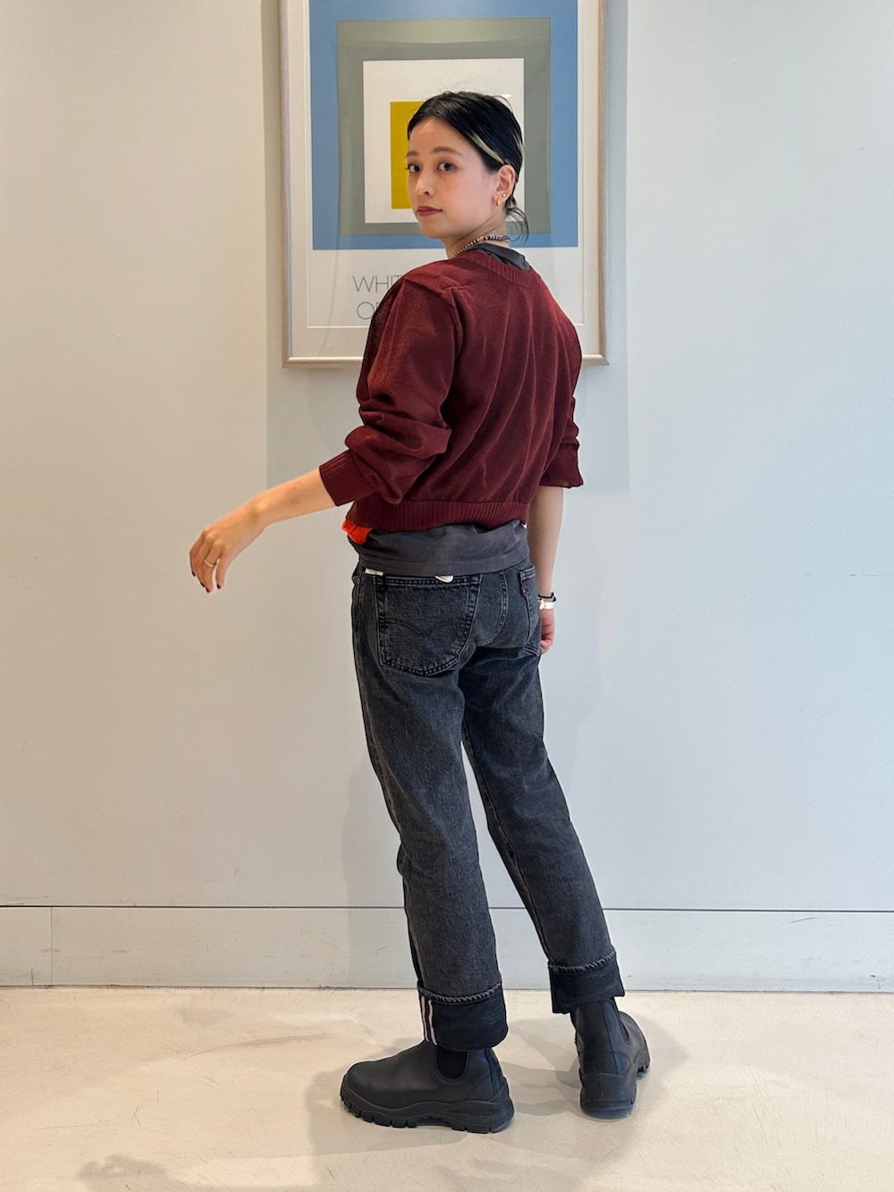 ブラック系のブーツ、レッド系のニット/セーター、ブラック系のTシャツ/カットソーを着用したレディースの春コーディネートの2枚目の写真