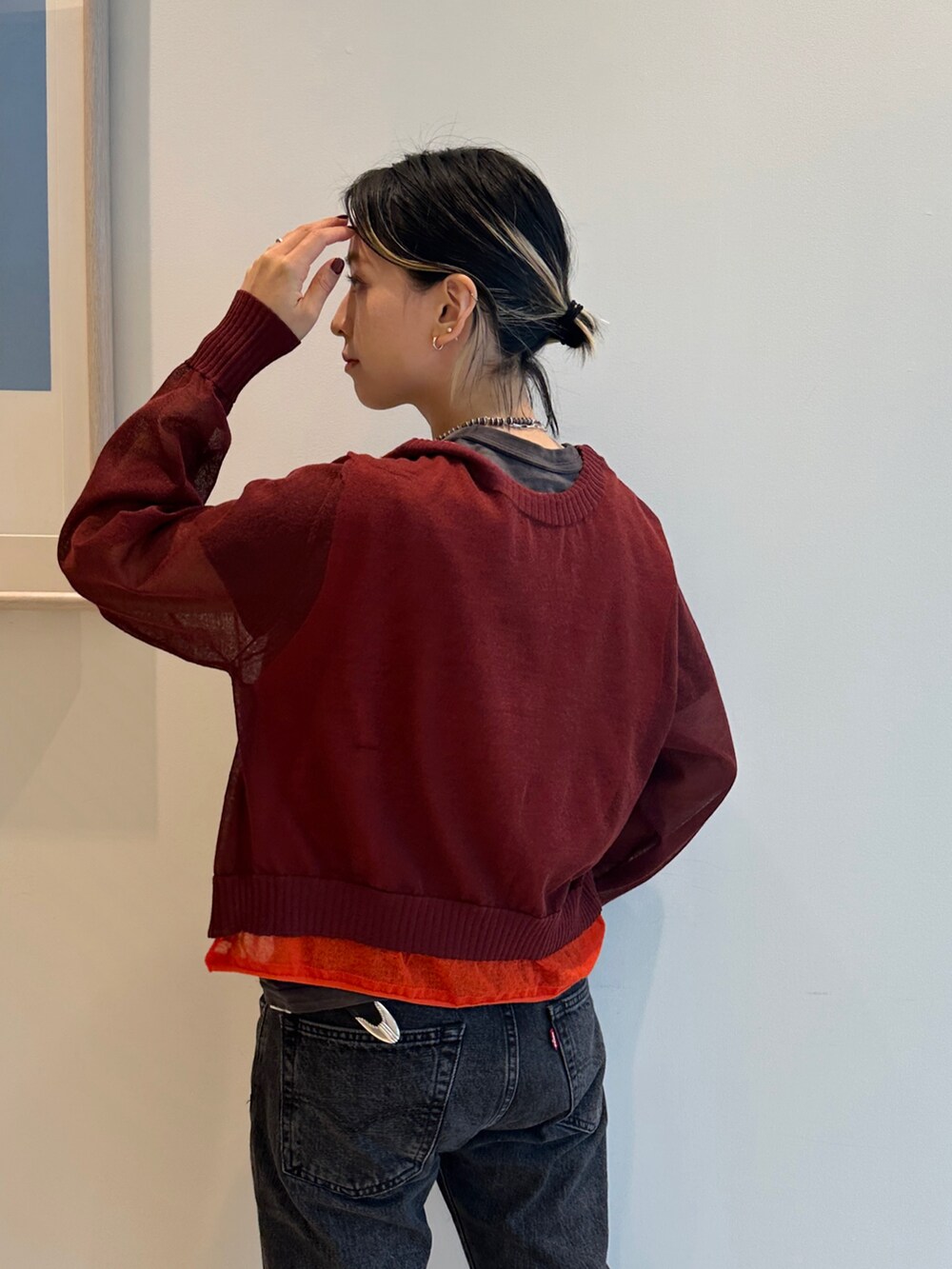 ブラック系のブーツ、レッド系のニット/セーター、ブラック系のTシャツ/カットソーを着用したレディースの春コーディネートの5枚目の写真