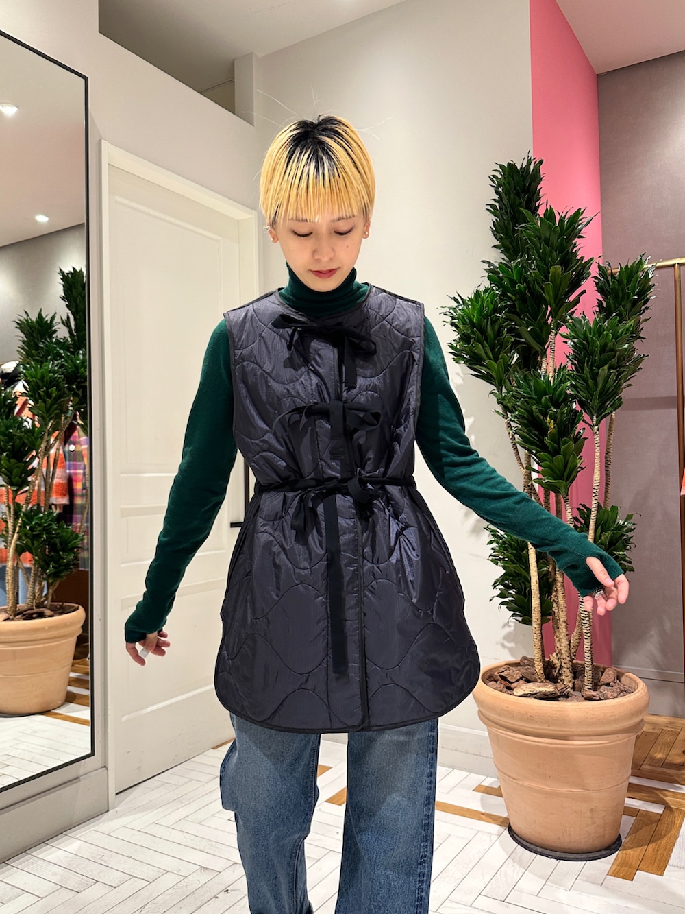 ブルー系のデニムパンツ、ブラック系のブーツ、グリーン系のニット/セーターを着用したレディースの冬コーディネートの4枚目の写真