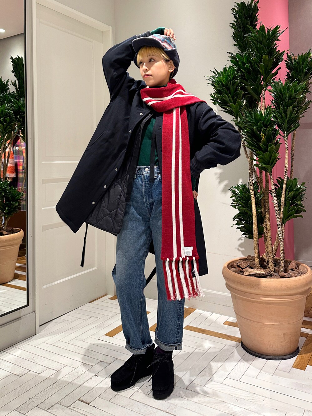 ブルー系のデニムパンツ、ブラック系のブーツ、グリーン系のニット/セーターを着用したレディースの冬コーディネートの2枚目の写真