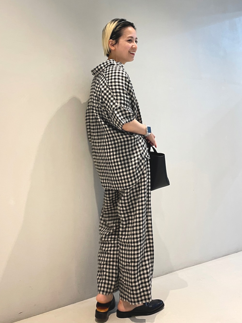 ブラック系のトートバッグ、ブラック系のシャツ/ブラウス、ブラック系のその他パンツを着用したレディースの春コーディネートの2枚目の写真