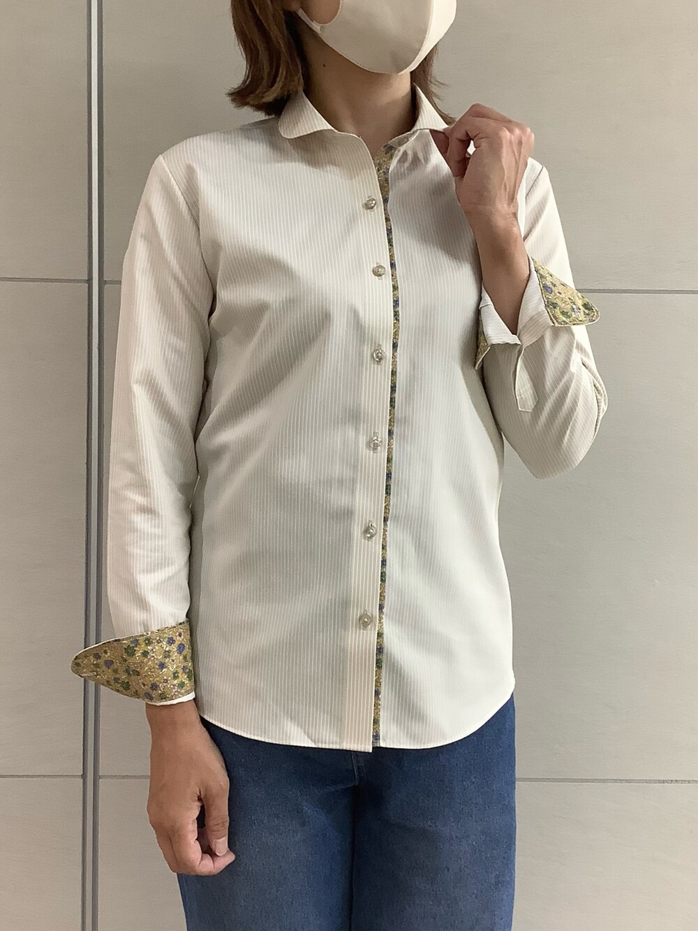 イエロー系のビジネスシャツを着用したレディースの秋コーディネートの2枚目の写真