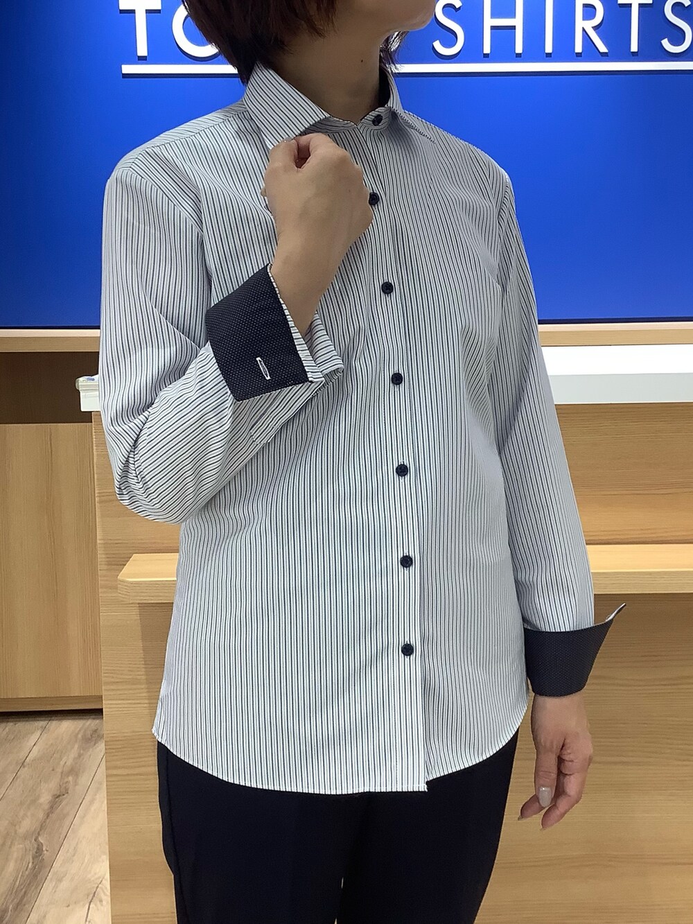 ブルー系のビジネスシャツを着用したレディースの秋コーディネートの2枚目の写真