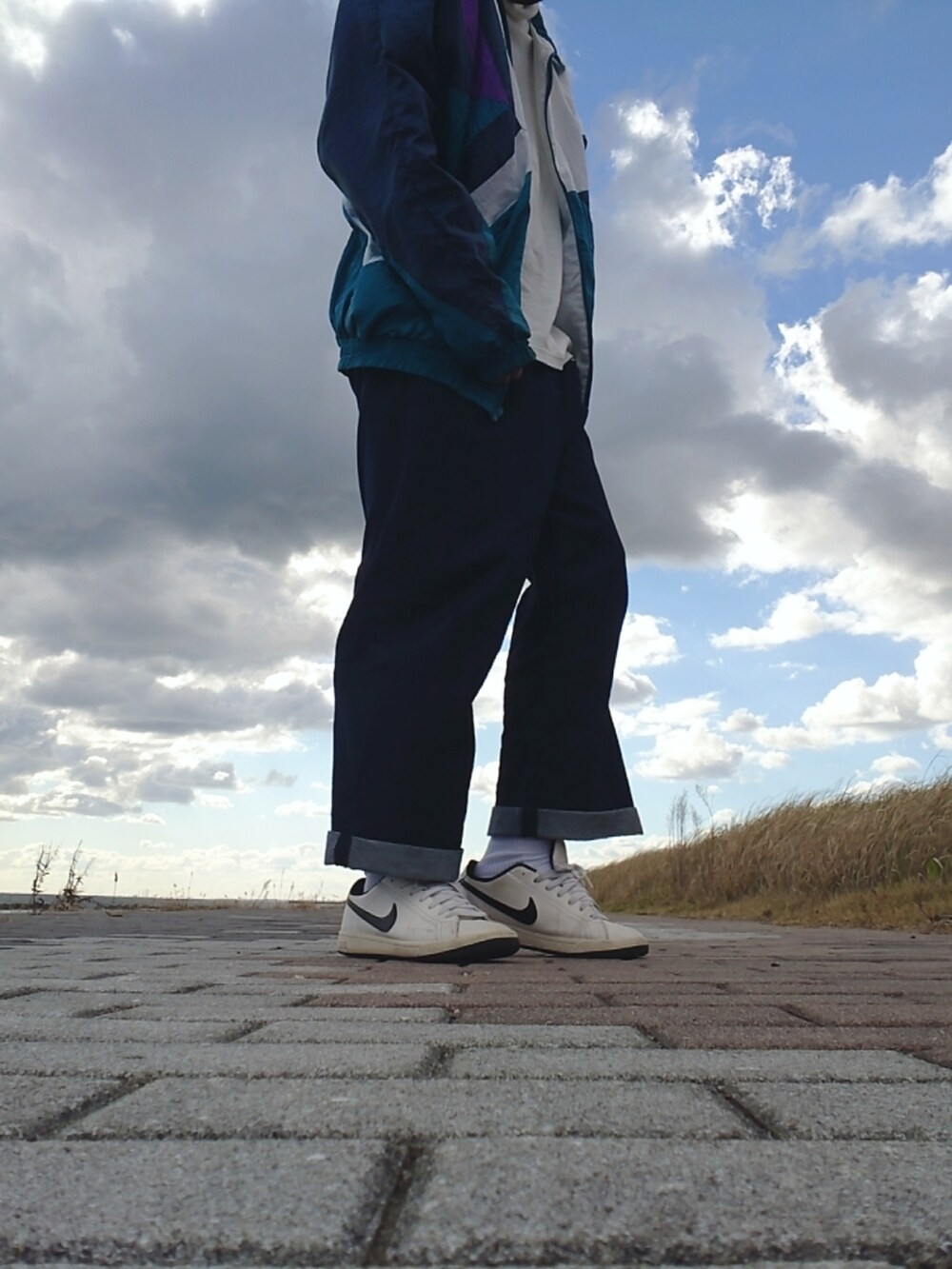 ブルー系のデニムパンツ、ホワイト系のキャップを着用したメンズの秋コーディネートの2枚目の写真