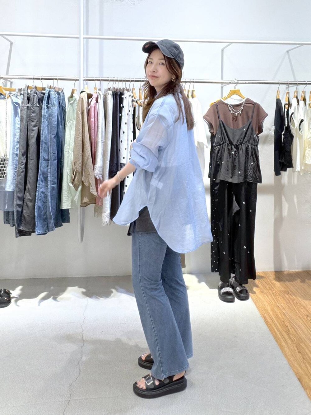 ブルー系のシャツ/ブラウス、ブラック系のサンダル、ブルー系のデニムパンツを着用したレディースの夏コーディネートの6枚目の写真