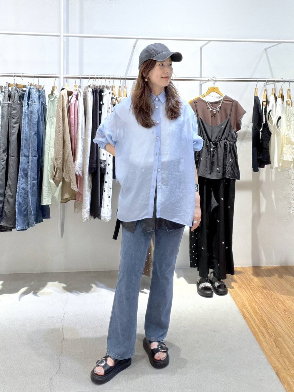 ブルー系のシャツ/ブラウス、ブラック系のサンダル、ブルー系のデニムパンツを着用したレディースの夏コーディネートの4枚目の写真