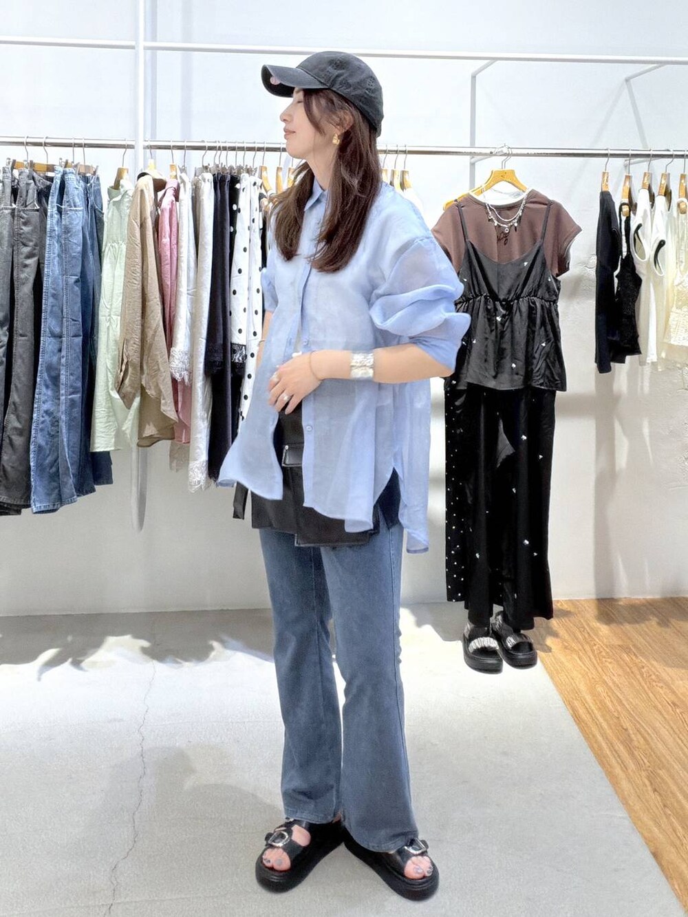 ブルー系のシャツ/ブラウス、ブラック系のサンダル、ブルー系のデニムパンツを着用したレディースの夏コーディネートの2枚目の写真