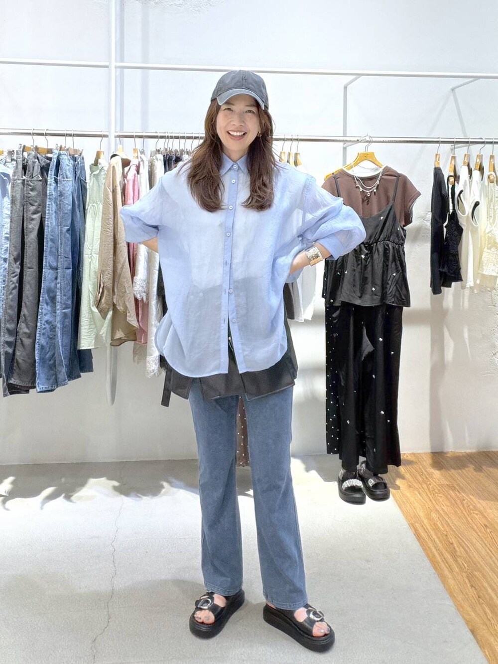 ブルー系のシャツ/ブラウス、ブラック系のサンダル、ブルー系のデニムパンツを着用したレディースの夏コーディネートの3枚目の写真