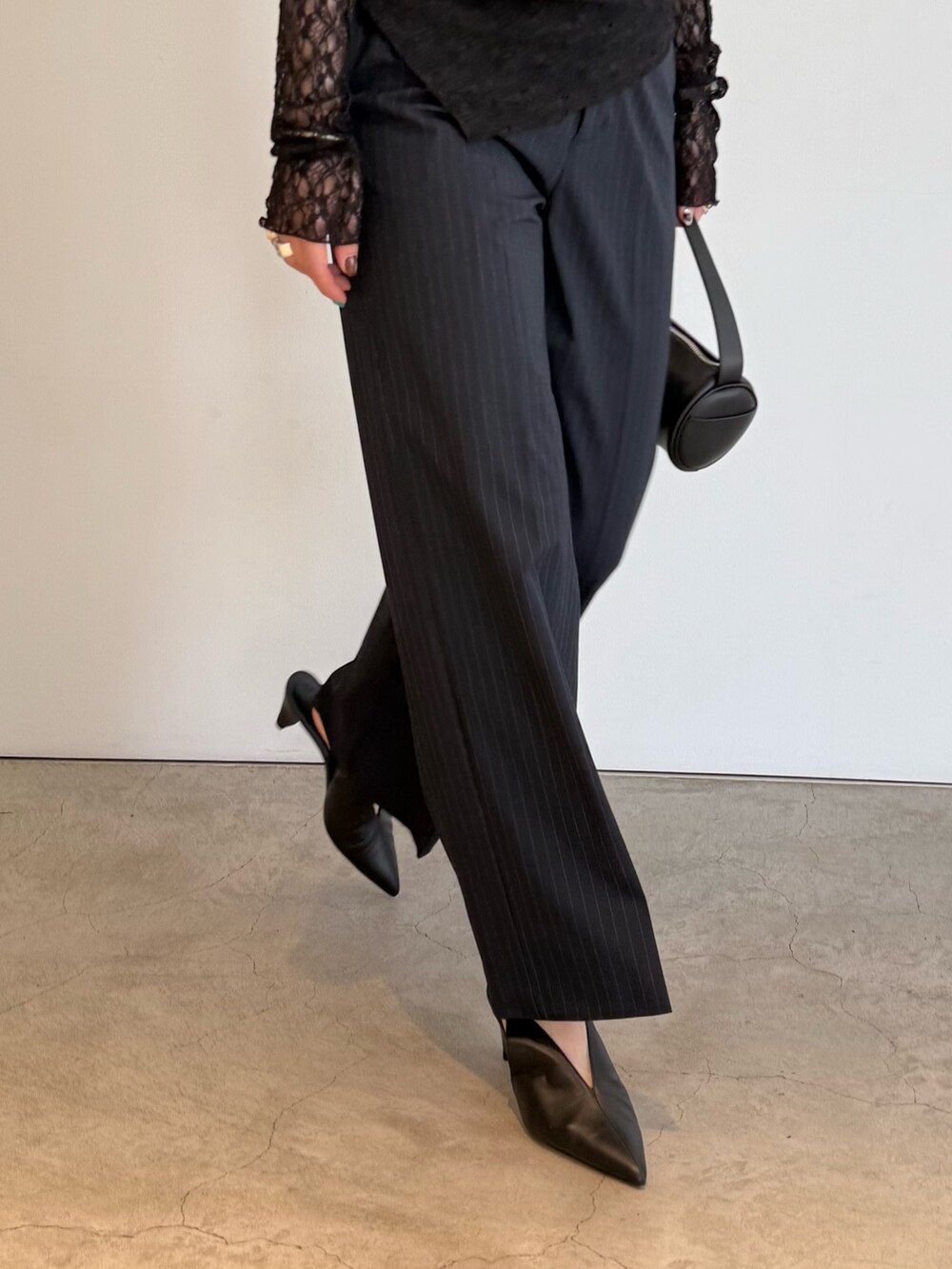 ブルー系のベスト、ブラック系のTシャツ/カットソー、ブルー系のスラックスを着用したレディースの夏コーディネートの4枚目の写真