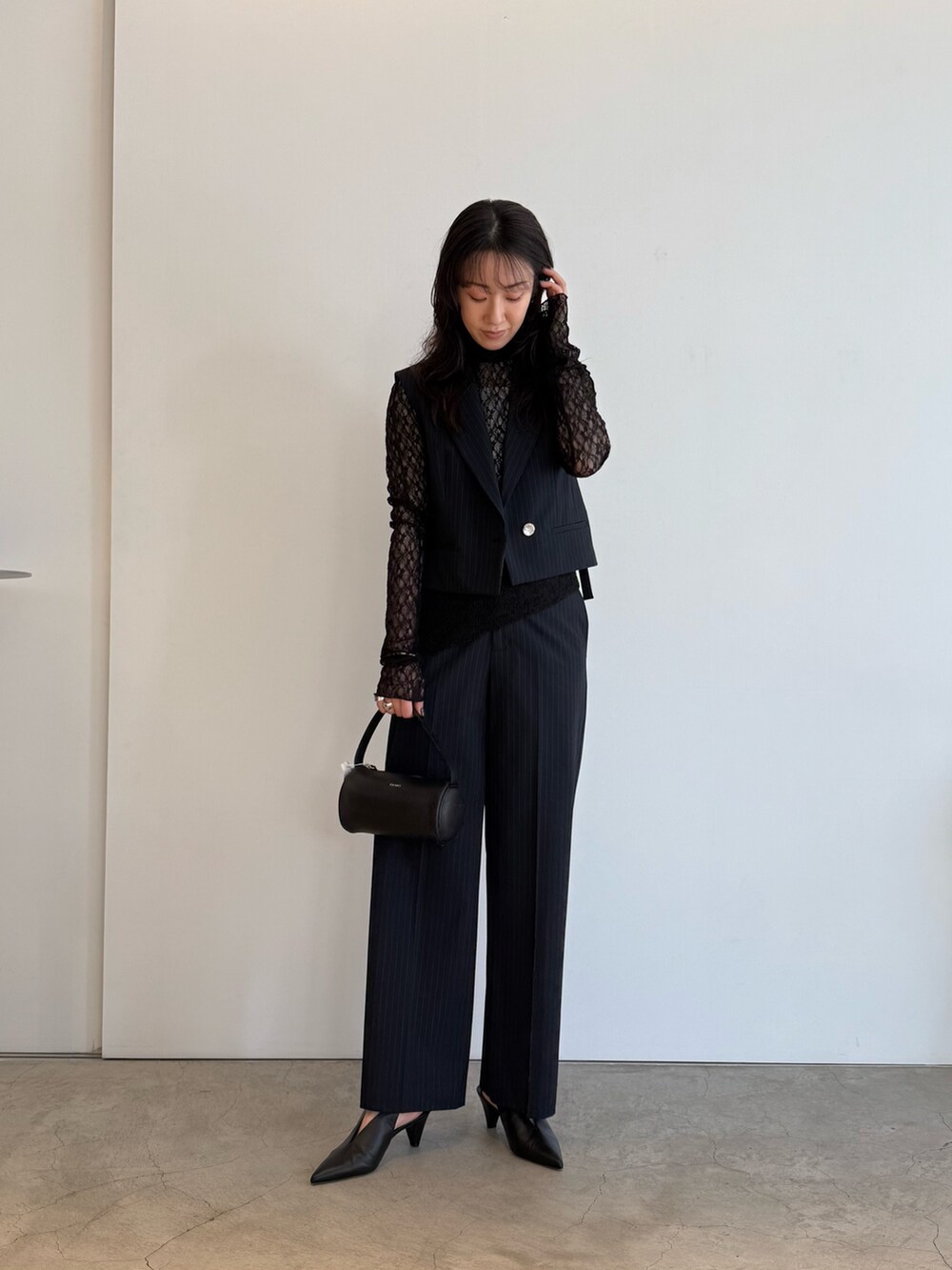 ブルー系のベスト、ブラック系のTシャツ/カットソー、ブルー系のスラックスを着用したレディースの夏コーディネートの2枚目の写真