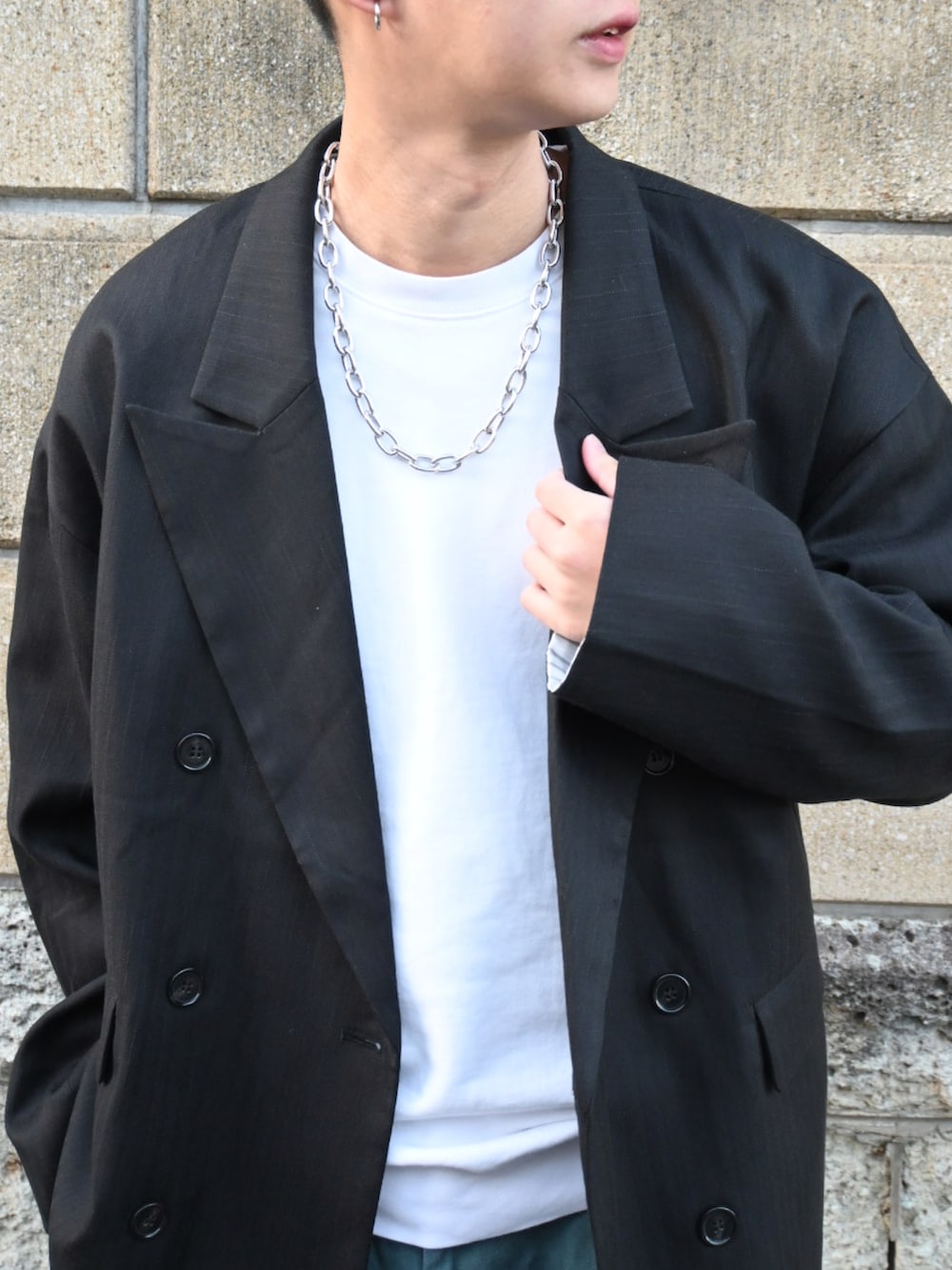 ブルー系のチノパンツ、ブラック系のスリッポン、ブラック系のテーラードジャケットを着用したメンズの冬コーディネートの2枚目の写真