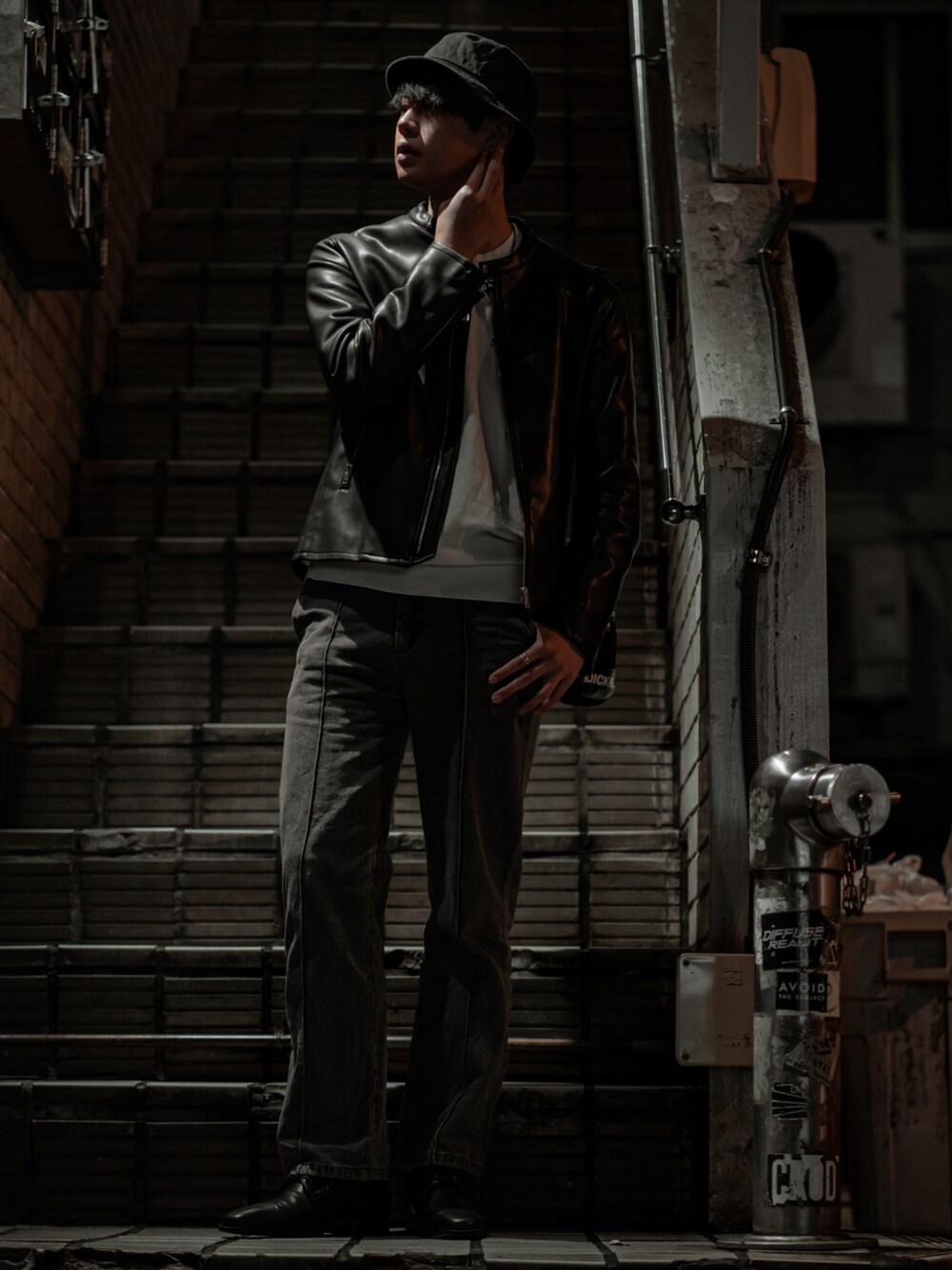 ブラック系のライダースジャケット、グレー系のデニムパンツ、ブラック系のドレスシューズを着用したメンズの春コーディネートの2枚目の写真