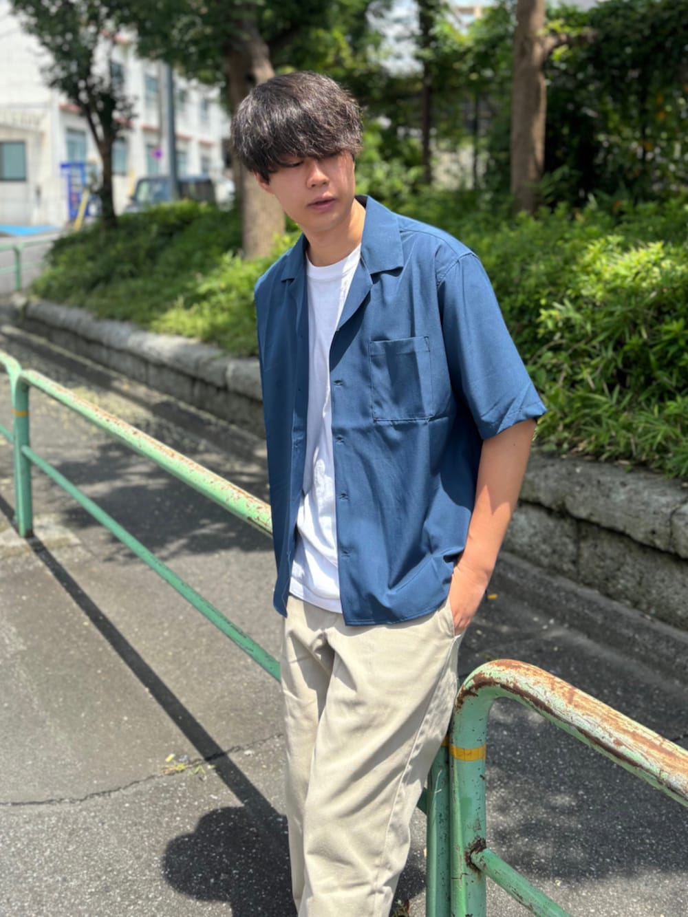 ブルー系のシャツ/ブラウス、ベージュ系のチノパンツ、ホワイト系のスニーカーを着用したメンズの夏コーディネートの2枚目の写真