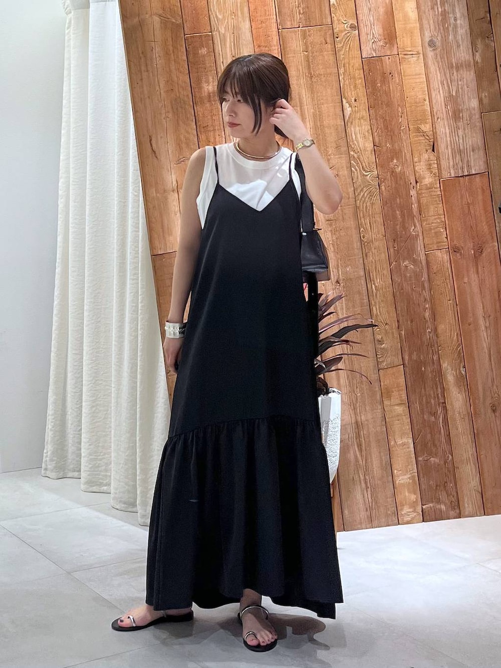 ブラック系のサンダル、ホワイト系のタンクトップ、グレー系のキャミソールを着用したレディースの夏コーディネートの2枚目の写真