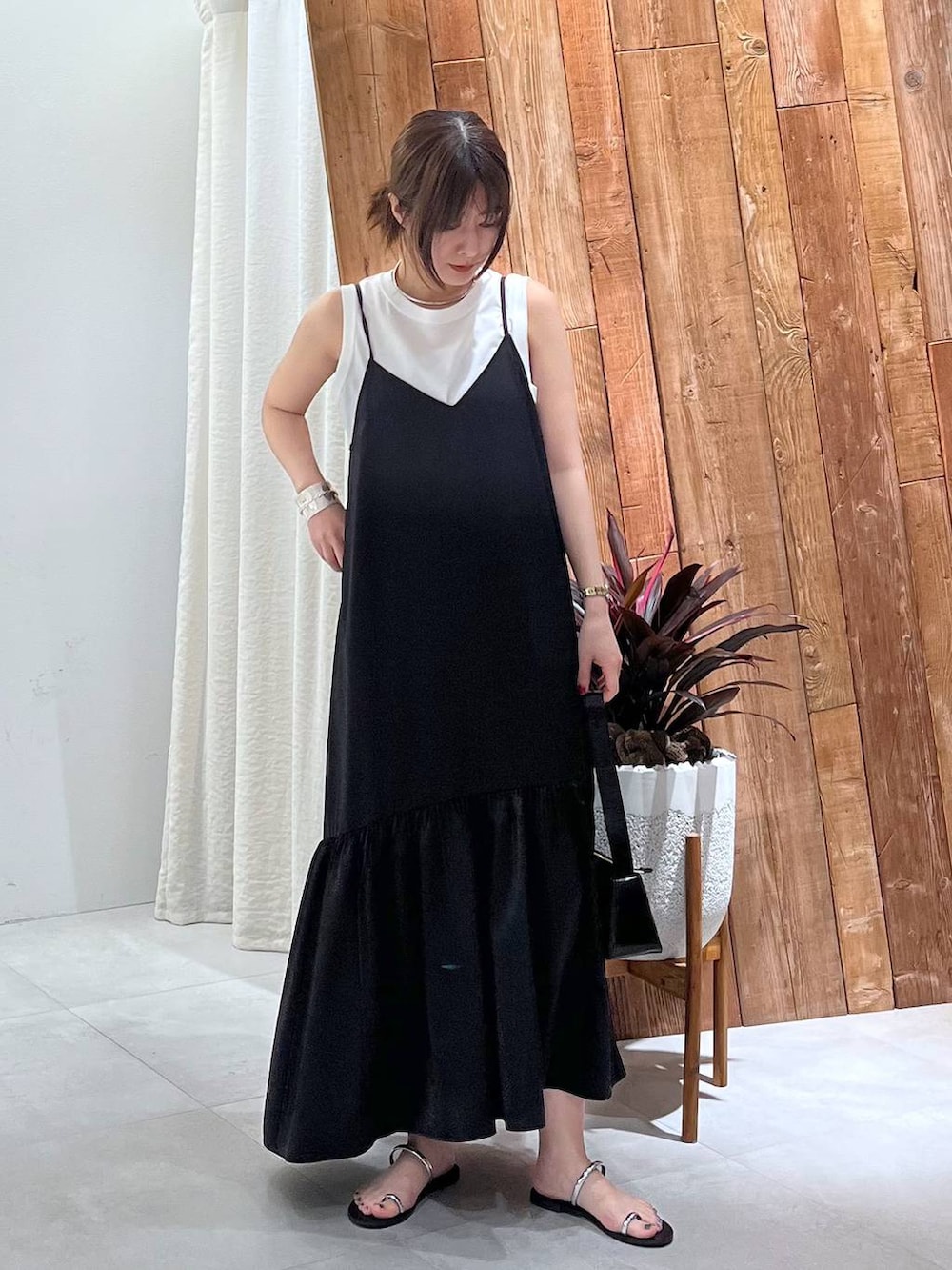 ブラック系のサンダル、ホワイト系のタンクトップ、グレー系のキャミソールを着用したレディースの夏コーディネートの3枚目の写真